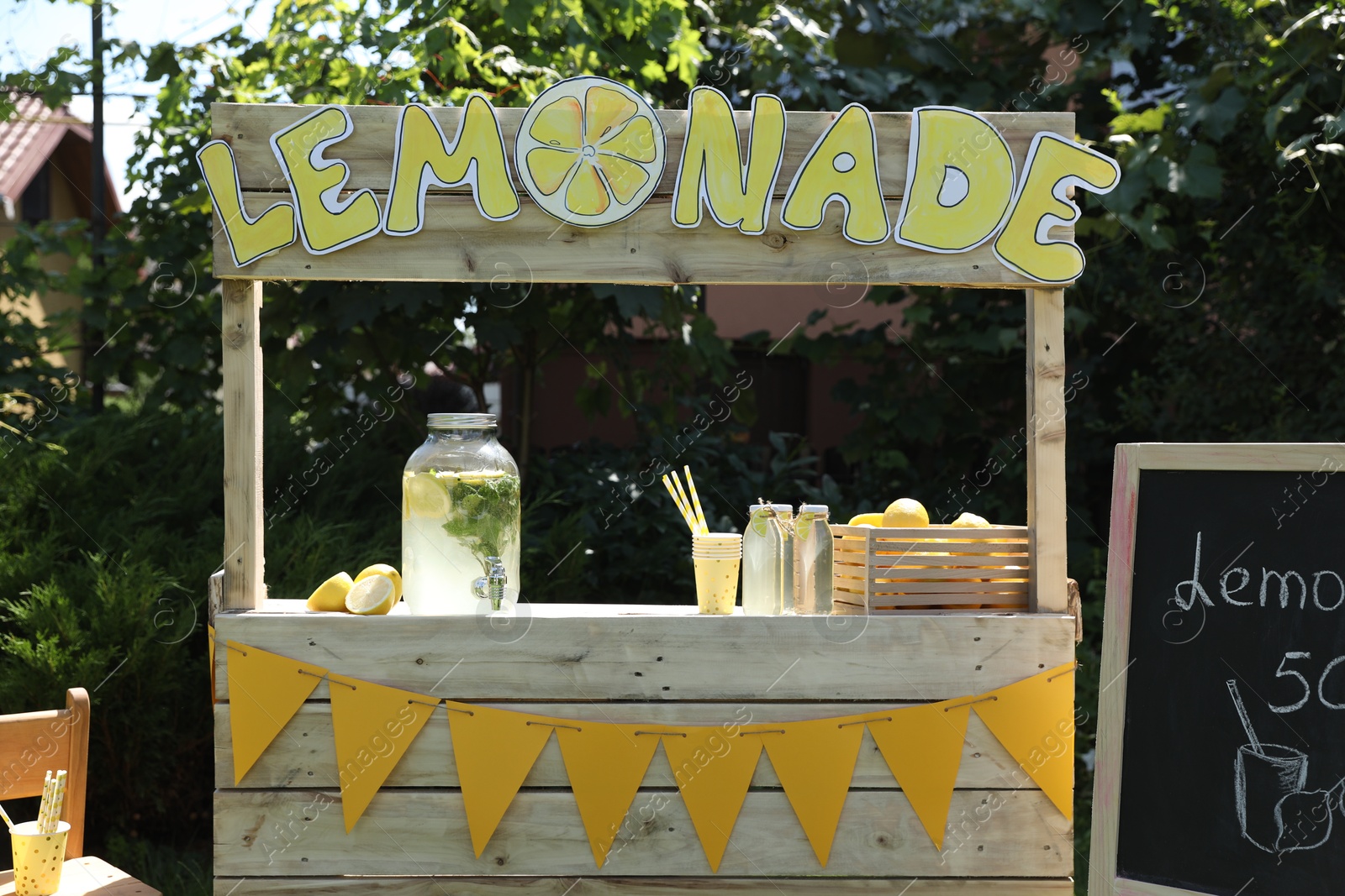 Photo of Lemonade stand with refreshing drink and fresh fruits in park