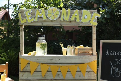 Lemonade stand with refreshing drink and fresh fruits in park