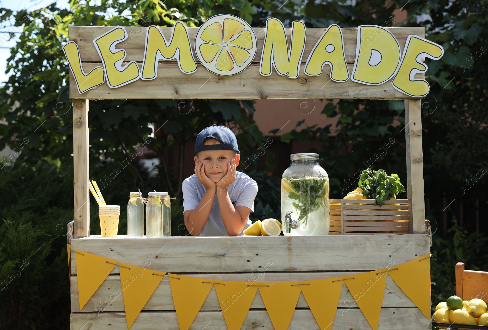 Photo of Cute little boy at lemonade stand in park