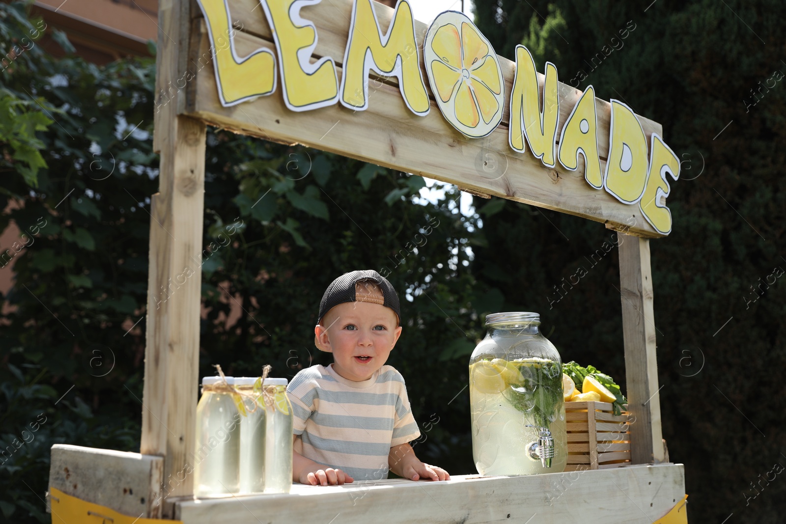 Photo of Cute little boy at lemonade stand in park