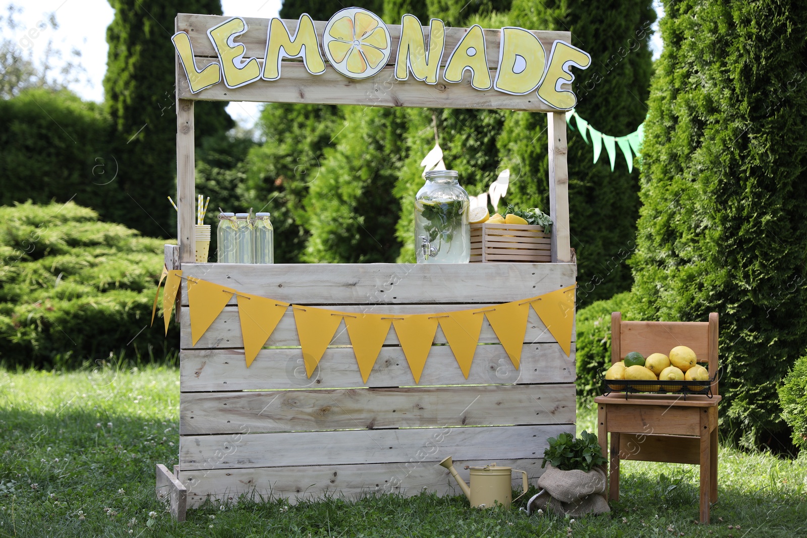 Photo of Lemonade stand with refreshing drink and fresh fruits in park