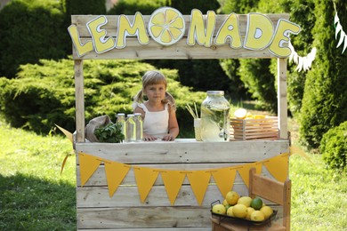 Photo of Cute little girl at lemonade stand in park