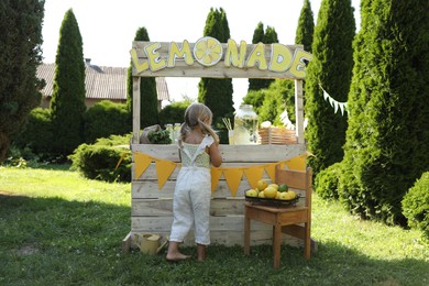 Photo of Little girl near lemonade stand in park