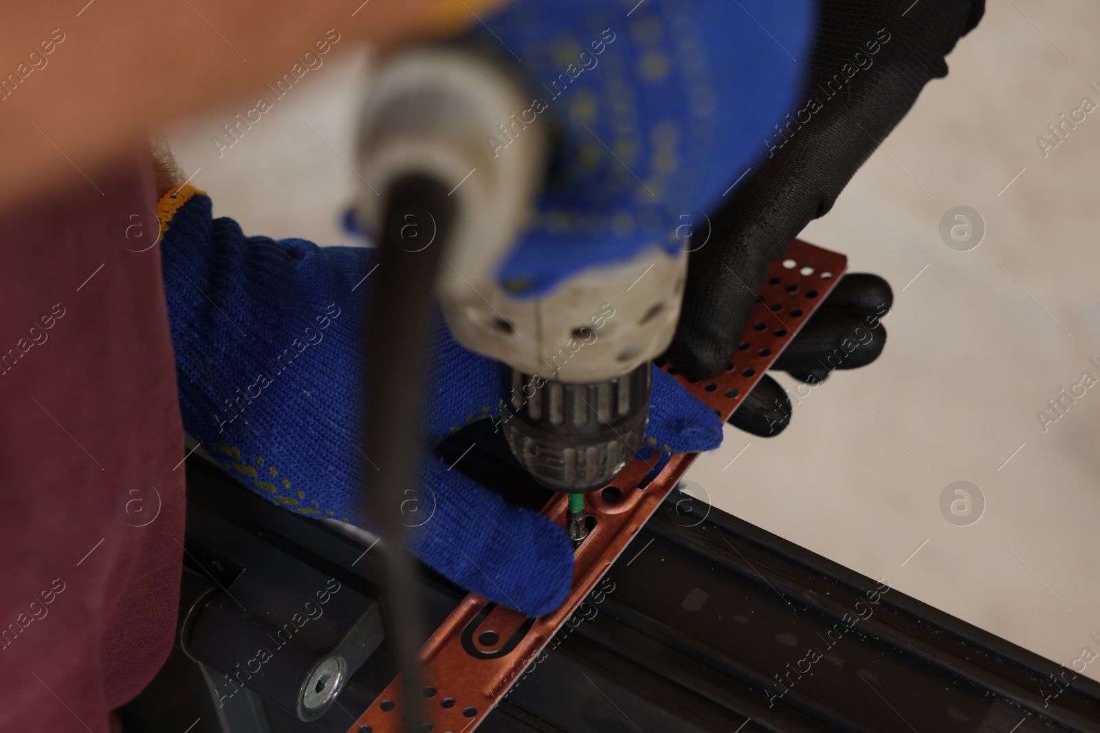 Photo of Repairman installing new window with electric screwdriver indoors, closeup