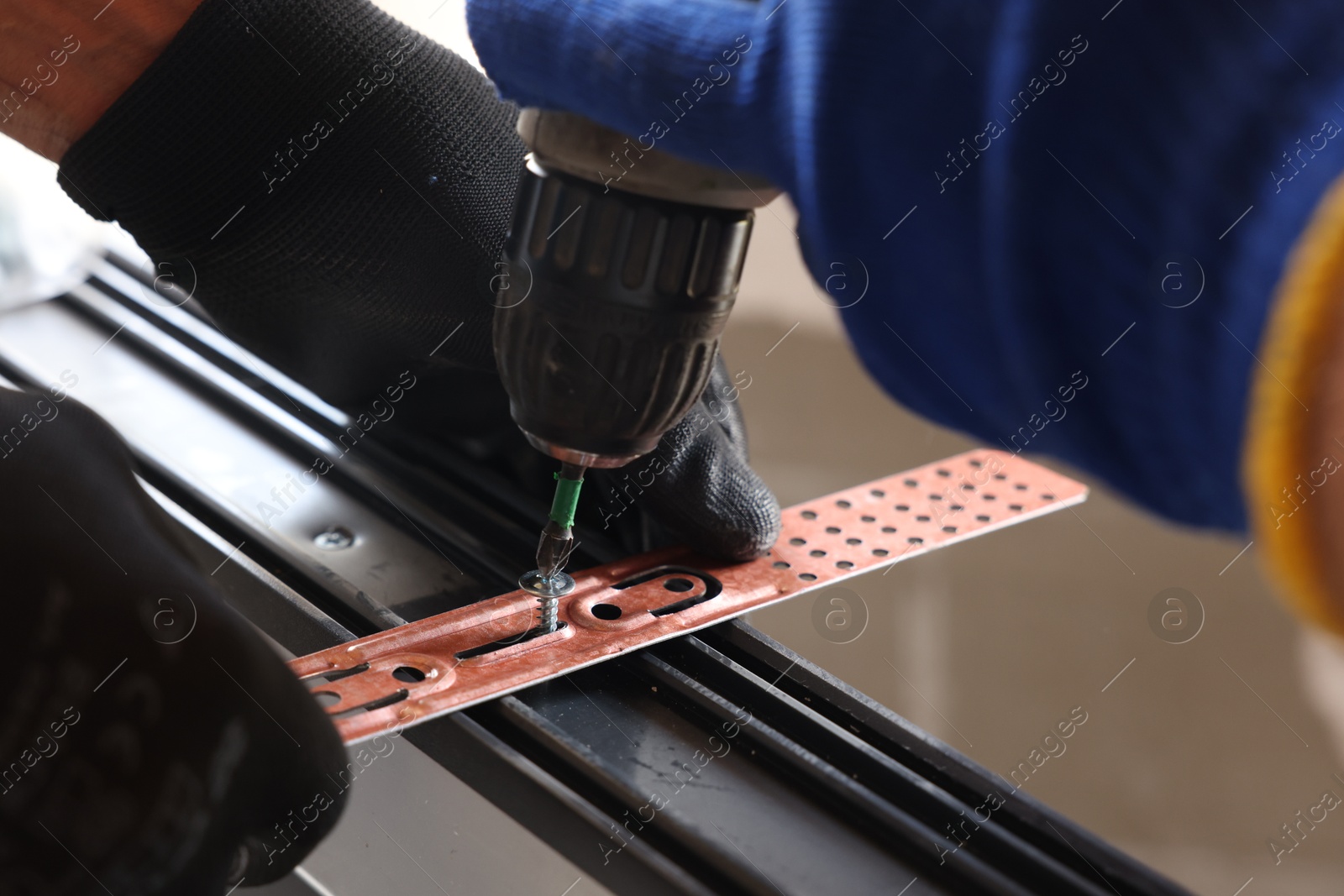 Photo of Repairman installing new window with electric screwdriver indoors, closeup