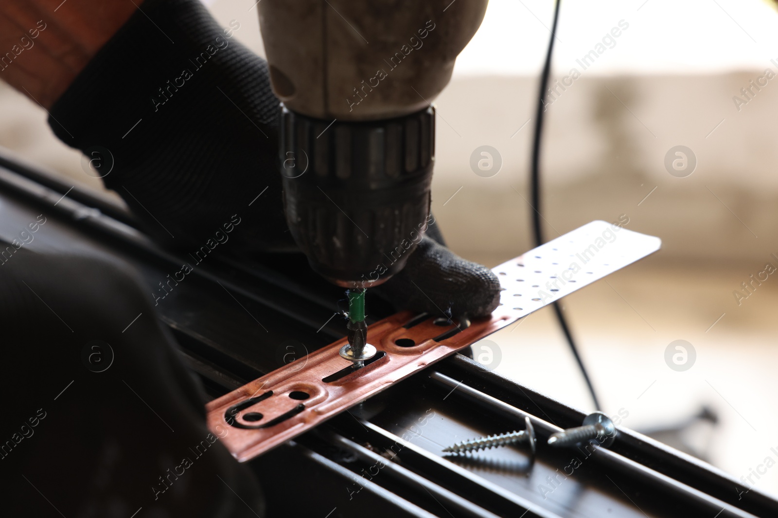 Photo of Repairman installing new window with electric screwdriver indoors, closeup