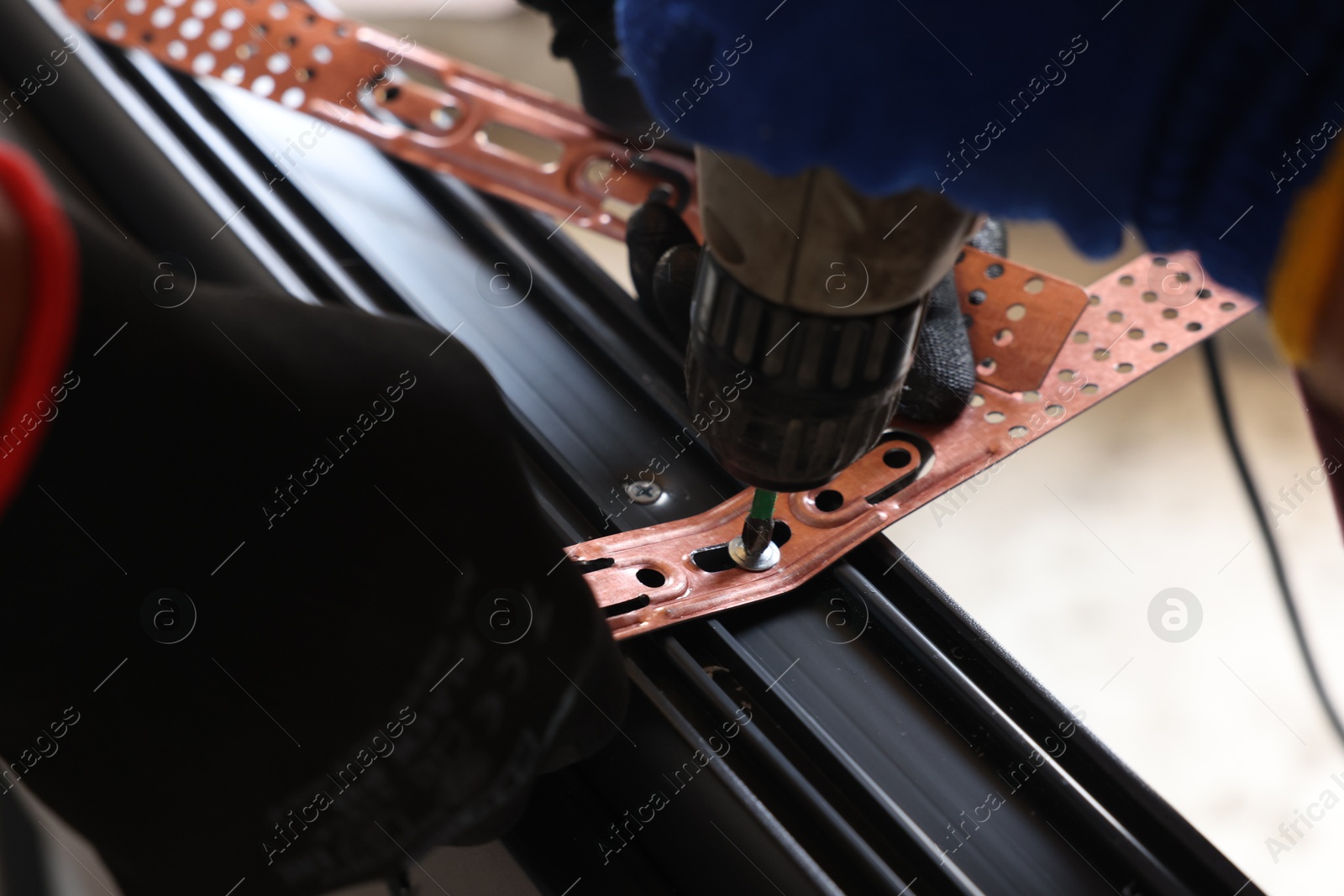 Photo of Repairman installing new window with electric screwdriver indoors, closeup