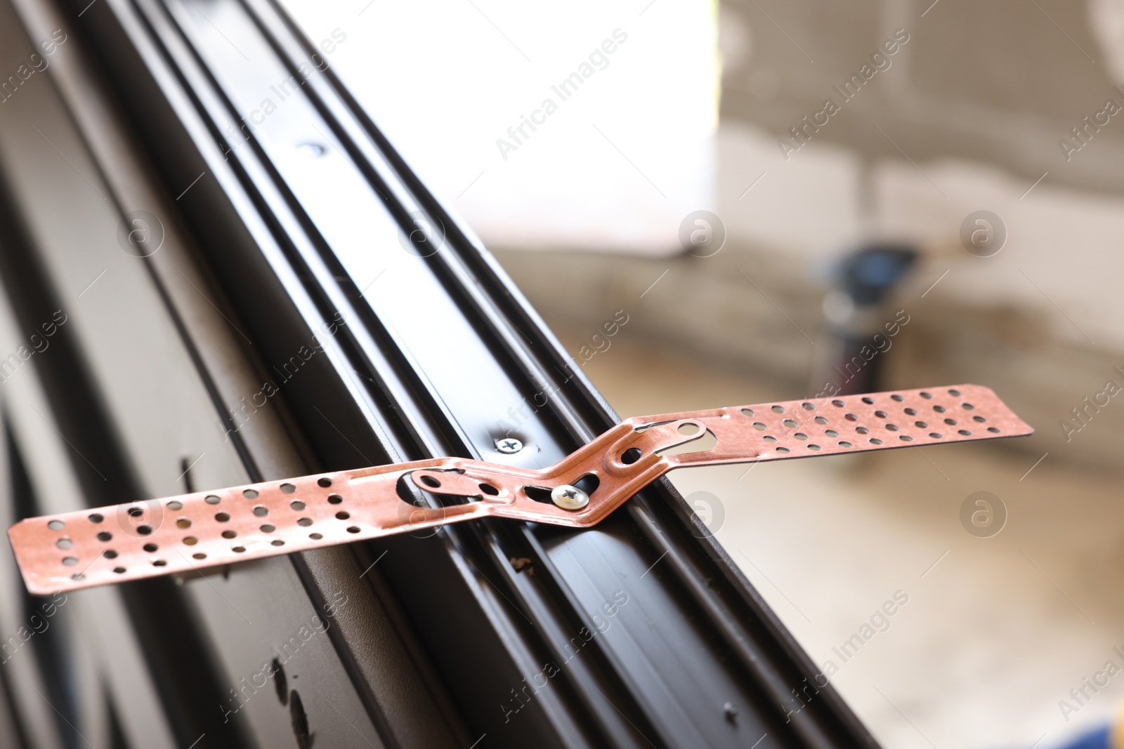 Photo of One copper hinge on newly installed window, closeup