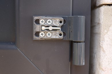 Photo of One metal hinge with screws on newly installed door, closeup