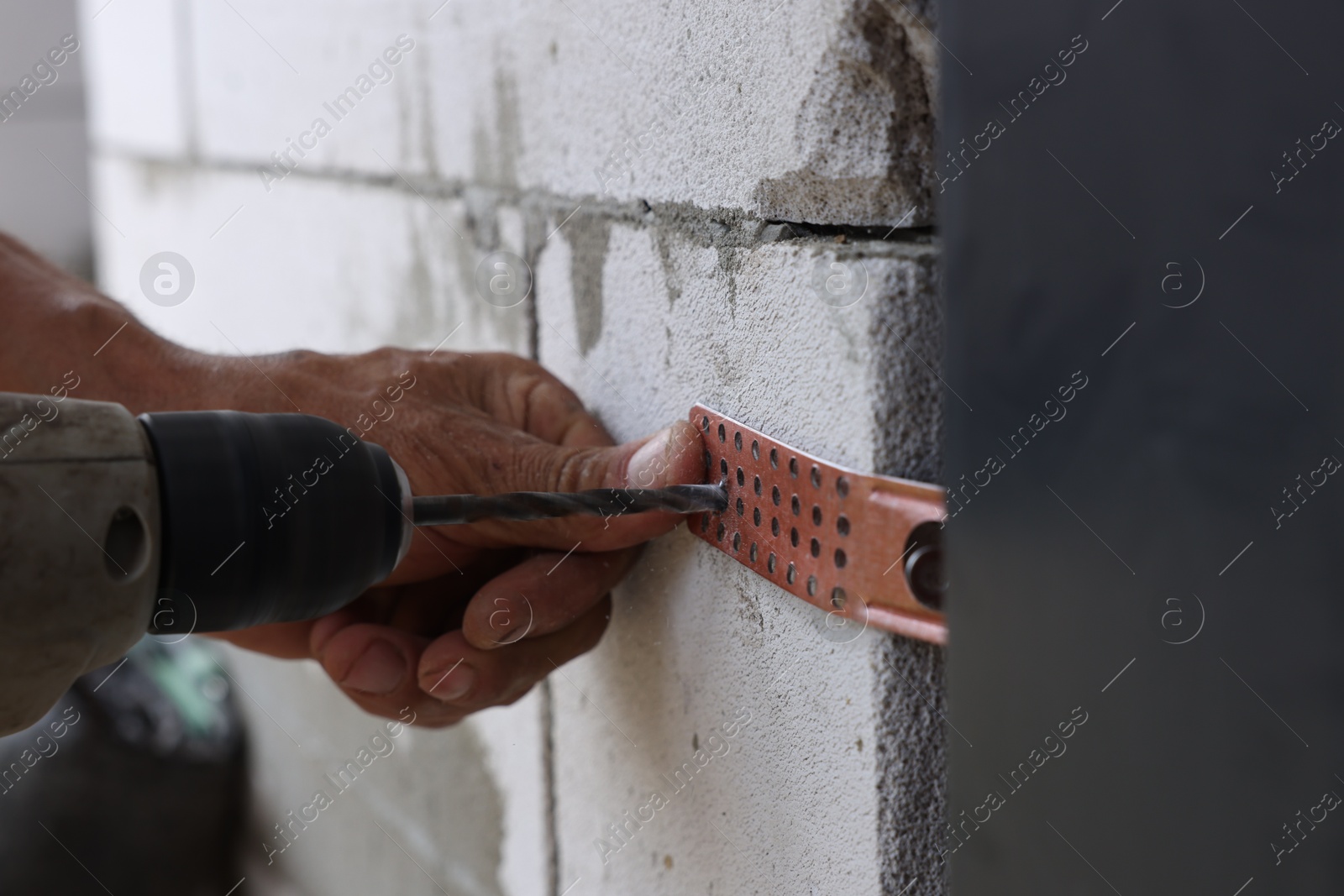 Photo of Repairman installing new door with electric screwdriver indoors, closeup