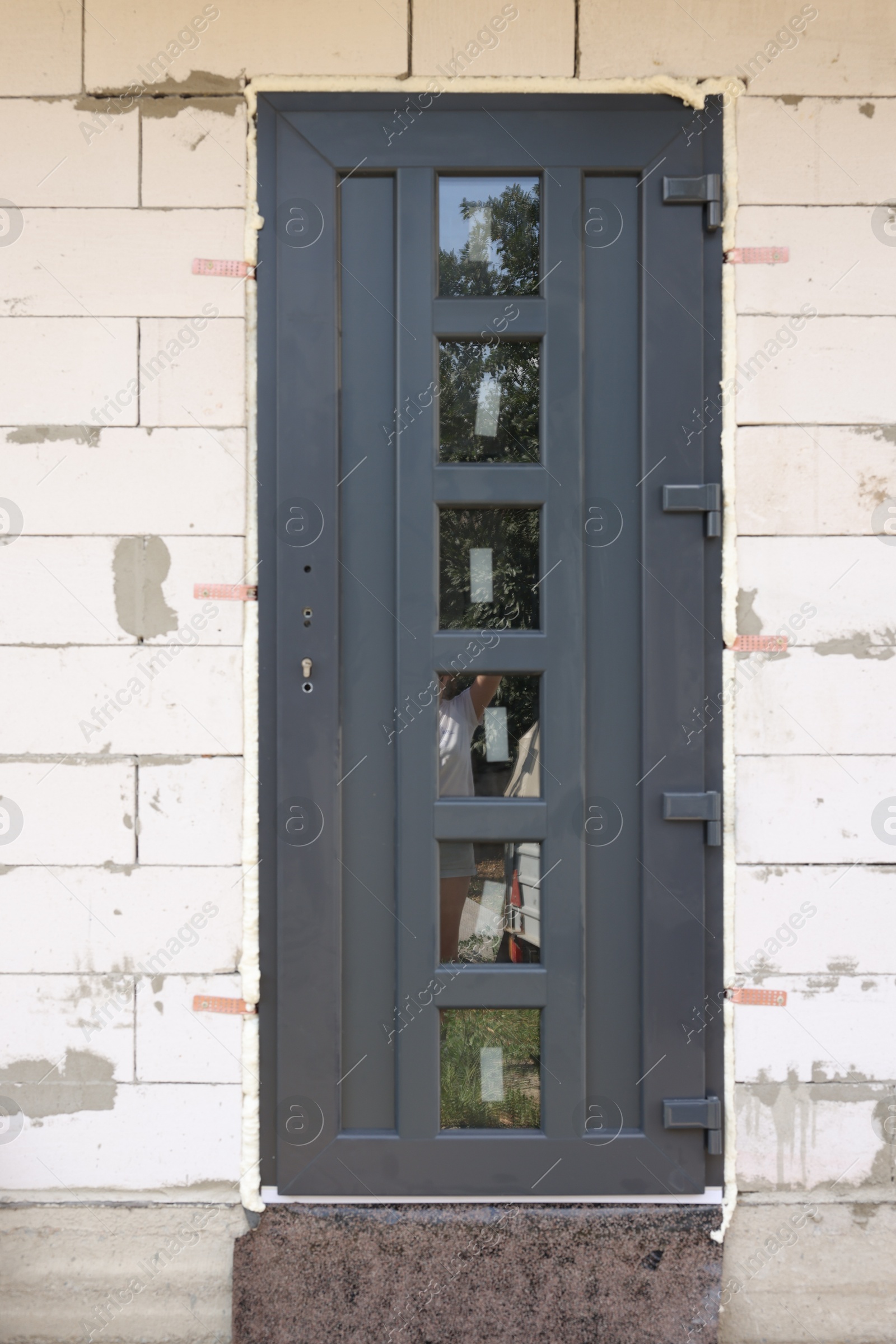 Photo of One grey newly installed door outdoors. Home renovation