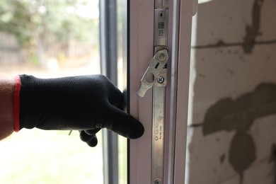 Photo of Repairman installing new window at home, closeup