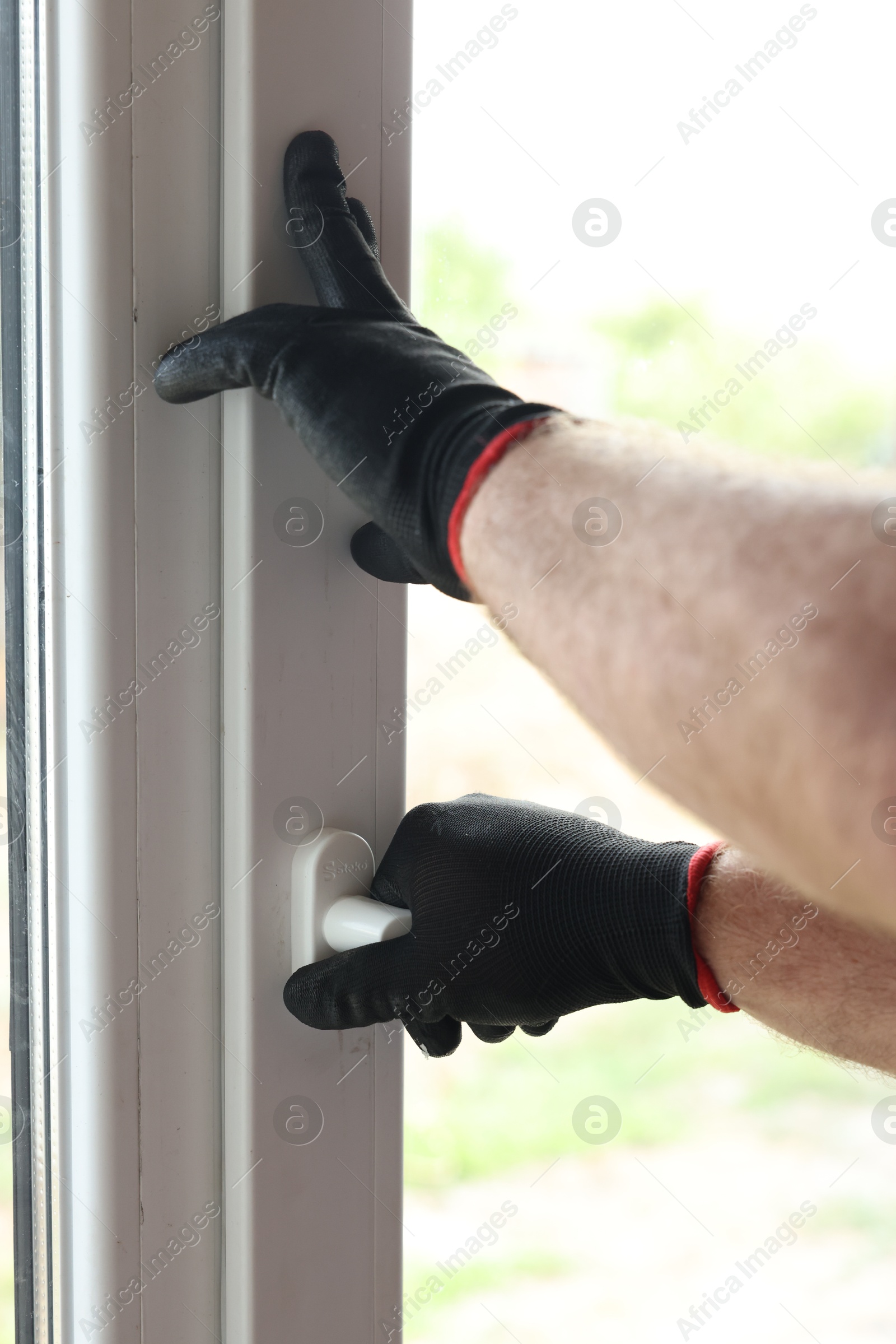 Photo of Repairman installing new window at home, closeup