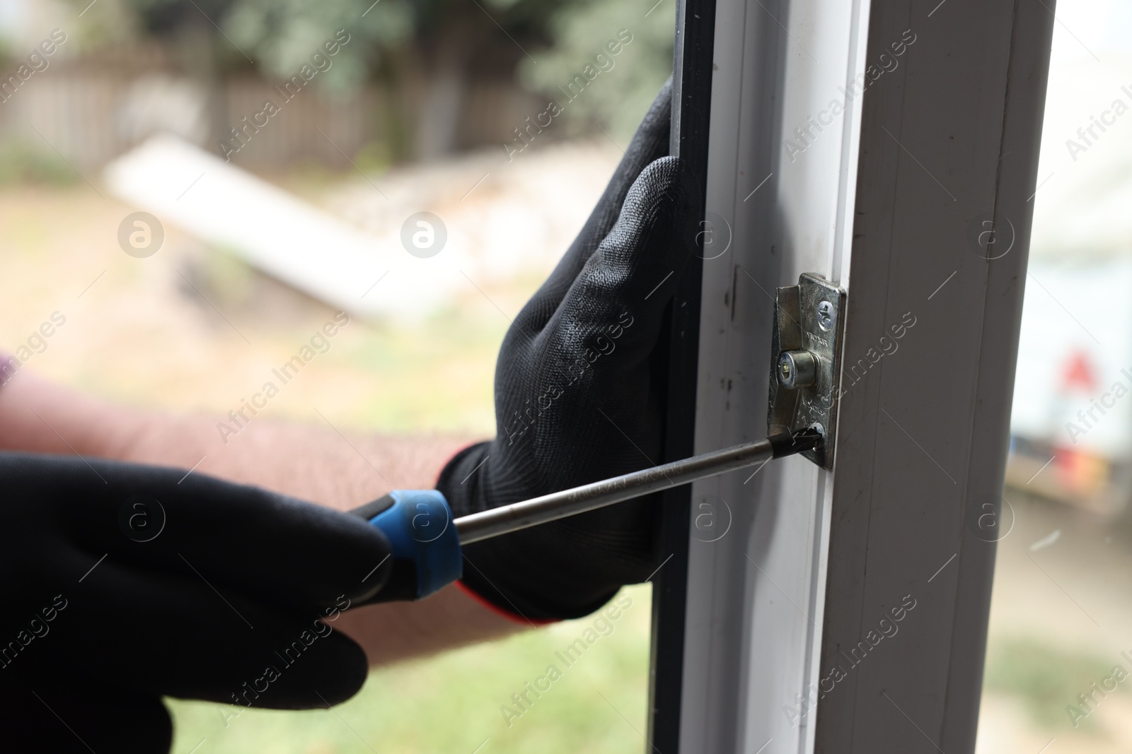 Photo of Repairman installing new window with screwdriver indoors, closeup