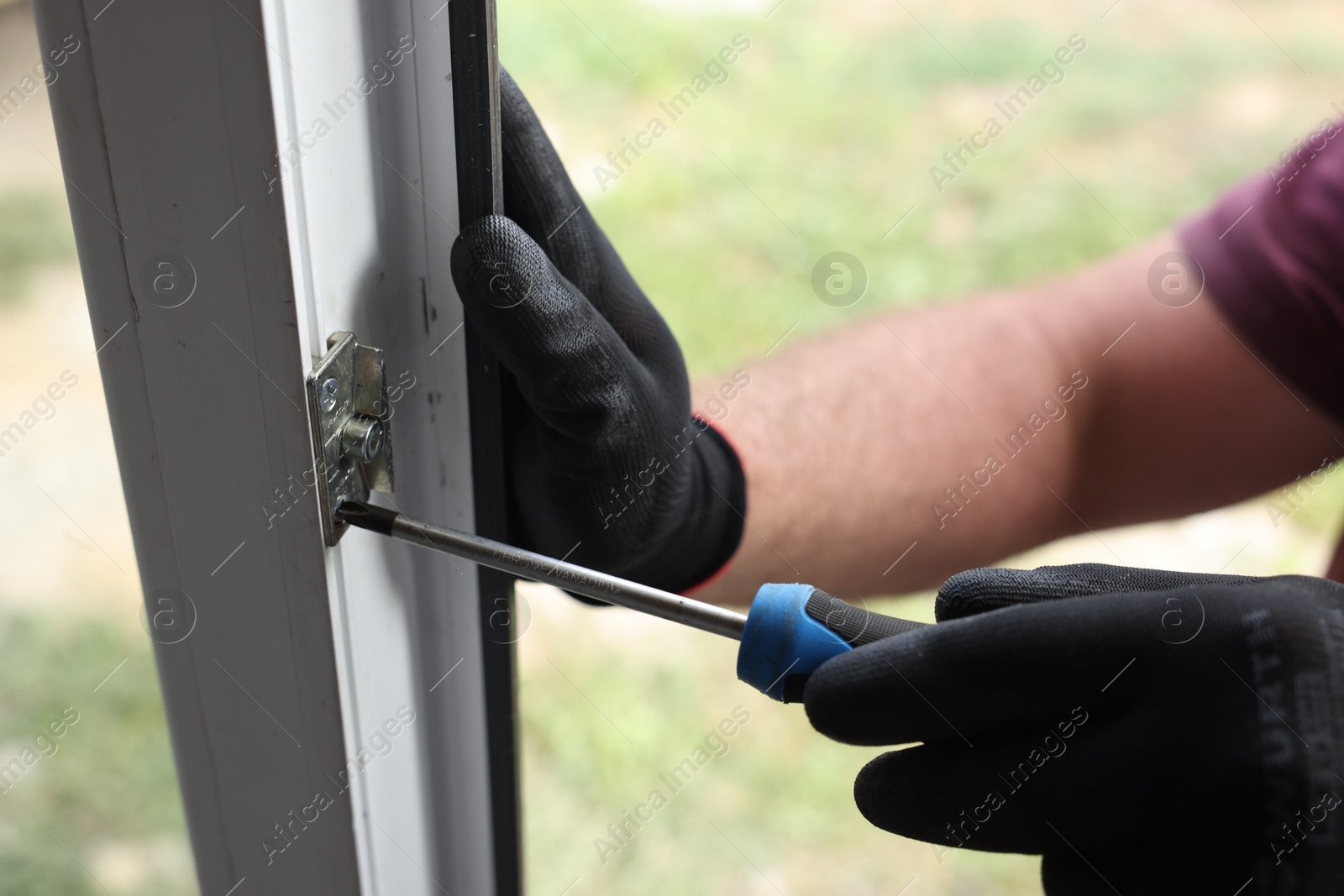 Photo of Repairman installing new window with screwdriver indoors, closeup