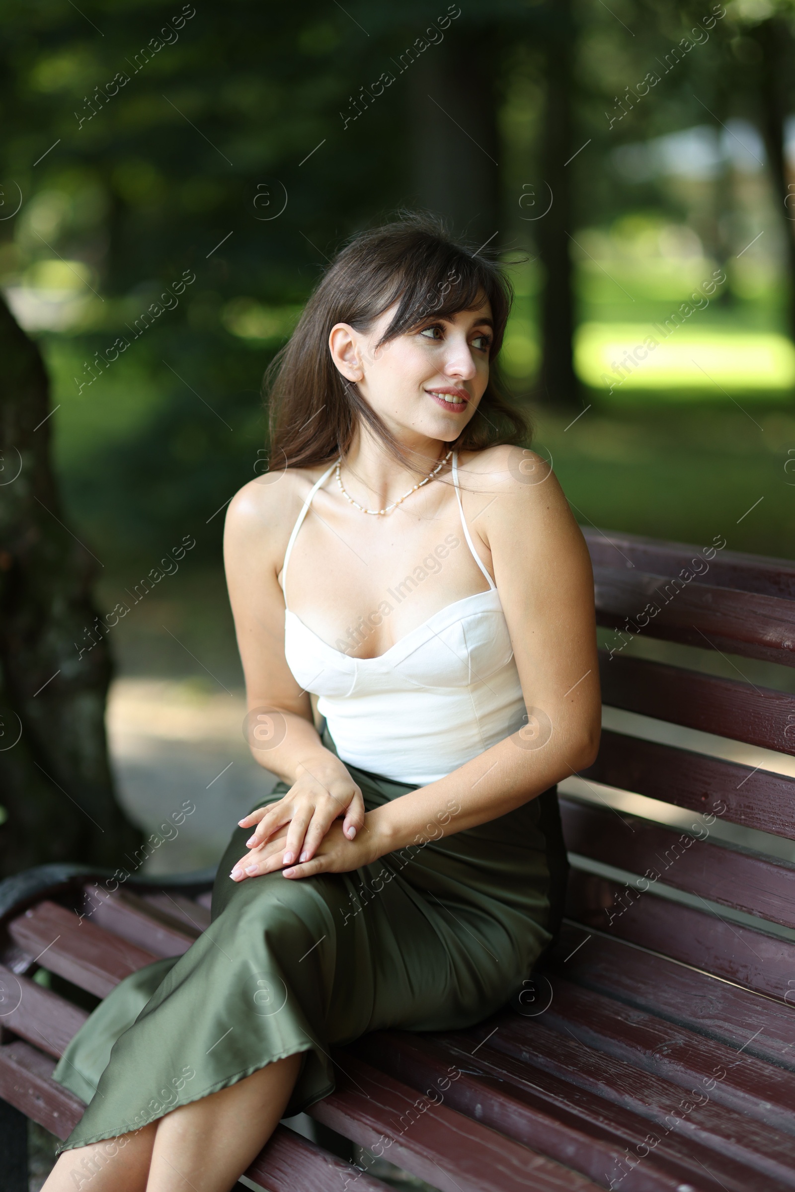 Photo of Smiling woman sitting on bench in park