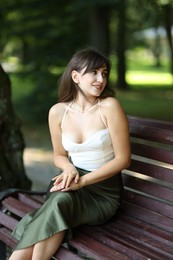 Smiling woman sitting on bench in park