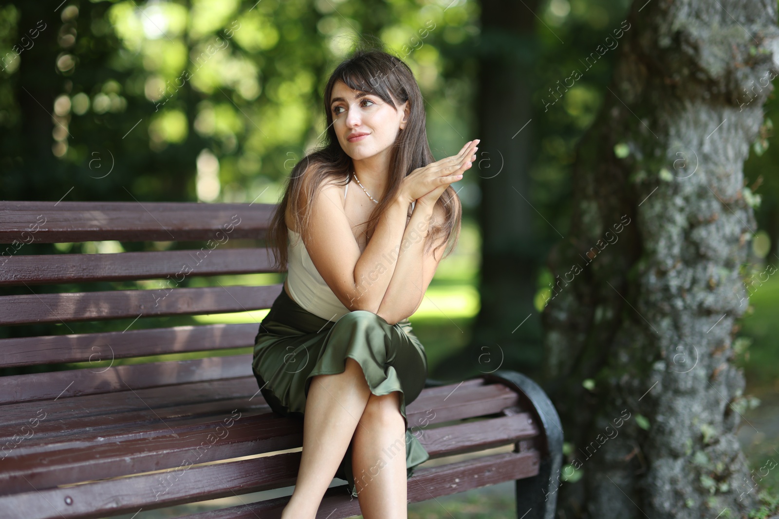 Photo of Beautiful woman sitting on bench in park