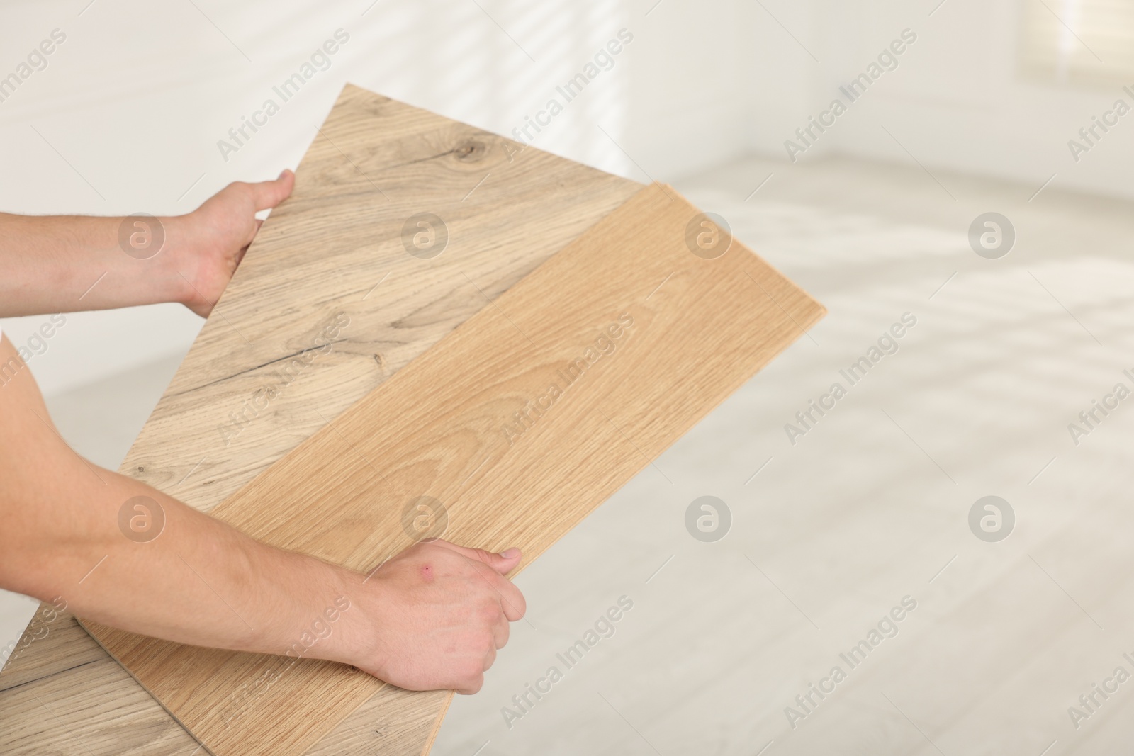 Photo of Man with samples of wooden flooring indoors, closeup