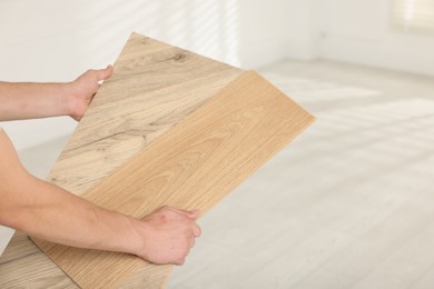 Photo of Man with samples of wooden flooring indoors, closeup