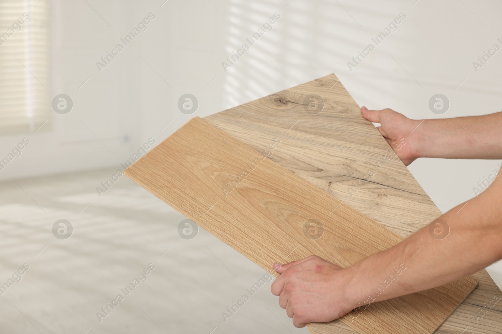 Photo of Man with samples of wooden flooring indoors, closeup