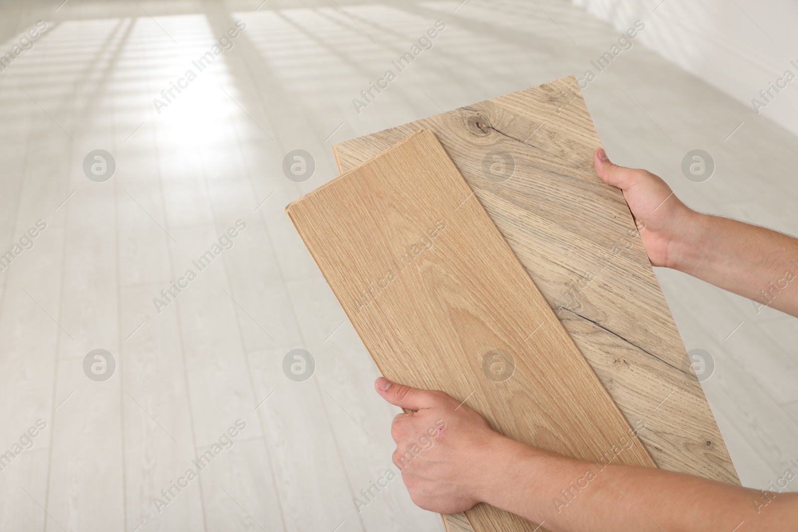 Photo of Man with samples of wooden flooring indoors, closeup. Space for text