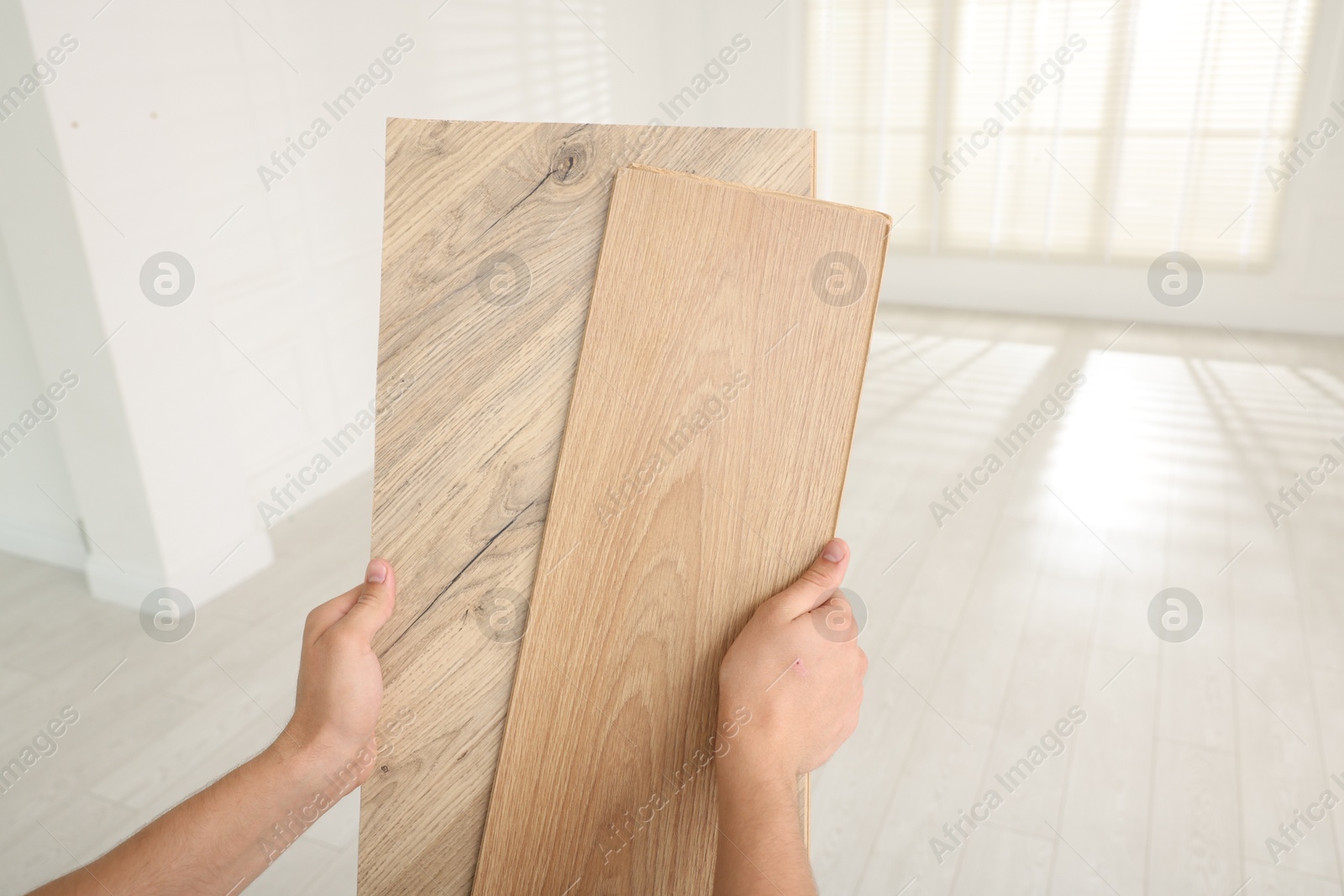 Photo of Man with samples of wooden flooring indoors, closeup