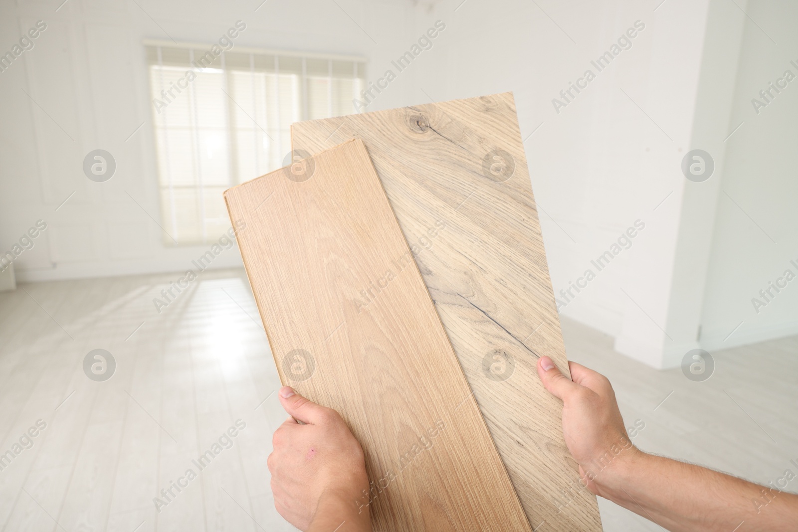 Photo of Man with samples of wooden flooring indoors, closeup