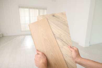 Photo of Man with samples of wooden flooring indoors, closeup