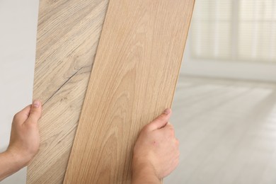 Photo of Man with samples of wooden flooring indoors, closeup