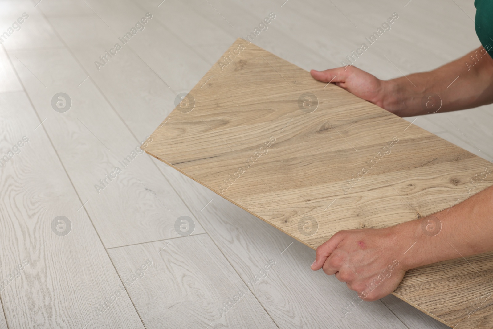 Photo of Man with sample of wooden flooring, closeup