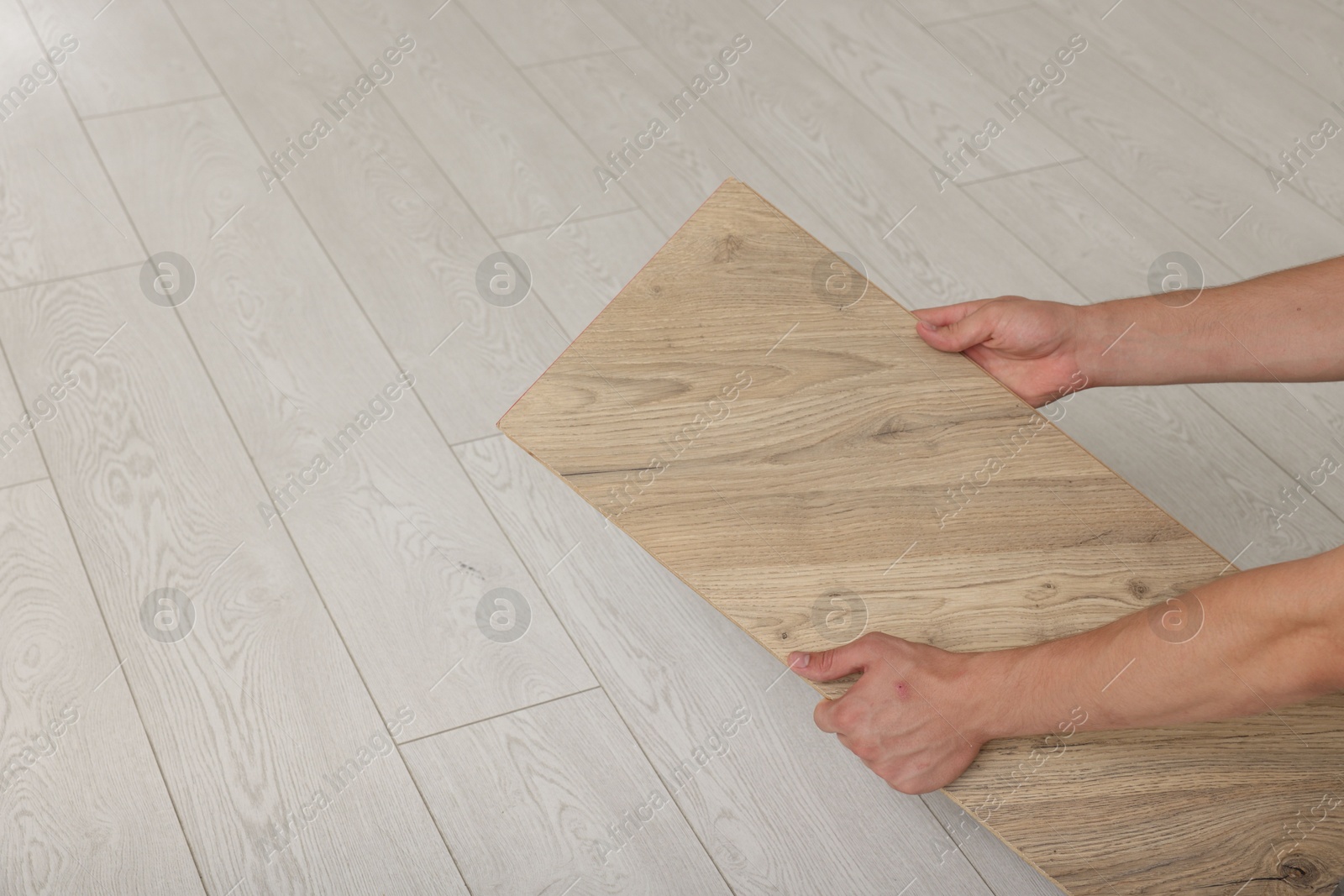 Photo of Man with sample of wooden flooring, closeup. Space for text