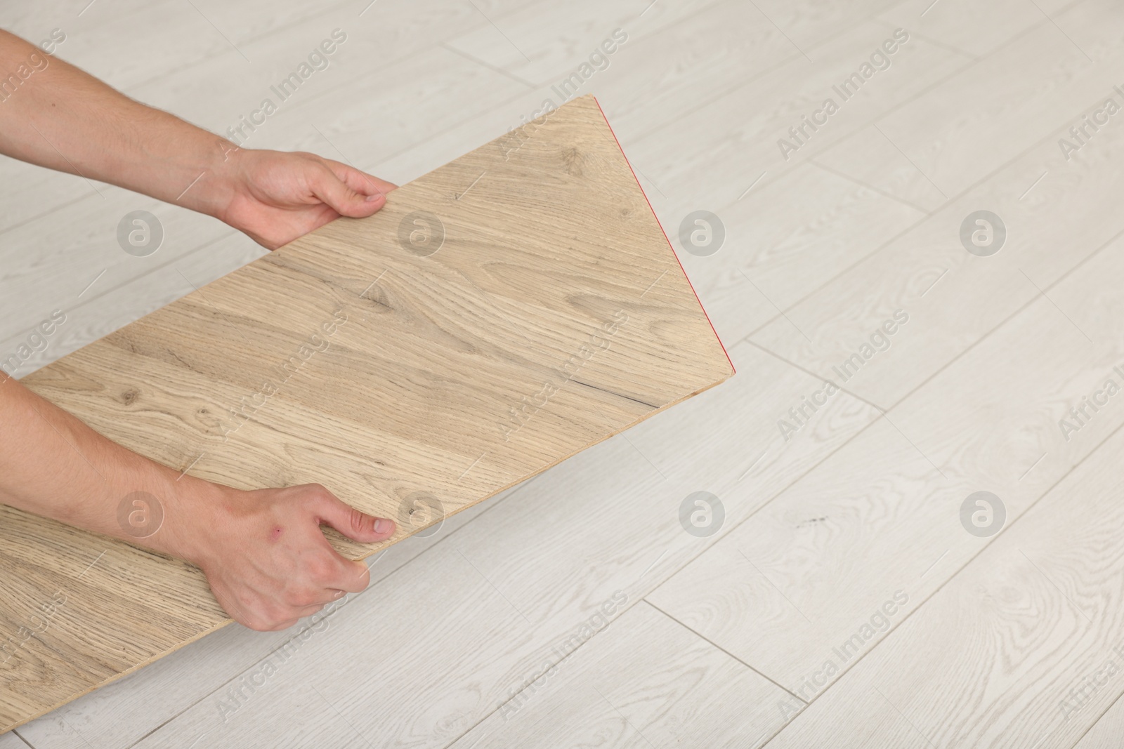 Photo of Man with sample of wooden flooring, closeup. Space for text