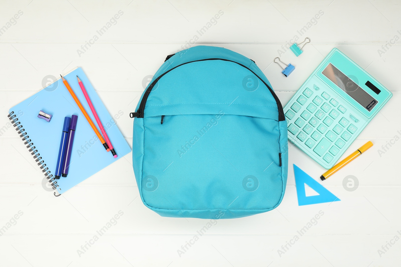 Photo of Backpack and different school supplies on white wooden background, flat lay