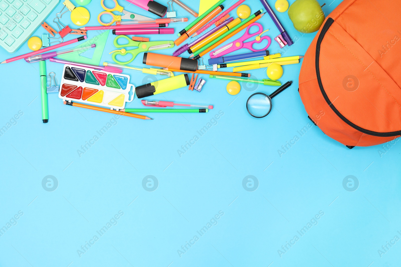 Photo of Backpack and different school supplies on light blue background, flat lay. Space for text