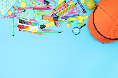 Backpack and different school supplies on light blue background, flat lay. Space for text