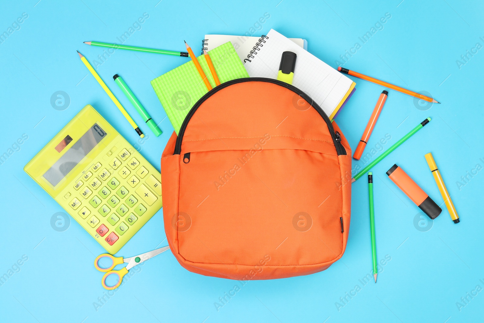 Photo of Backpack and different school supplies on light blue background, flat lay