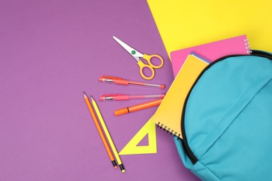 Photo of Flat lay composition with backpack and different school stationery on color background, space for text