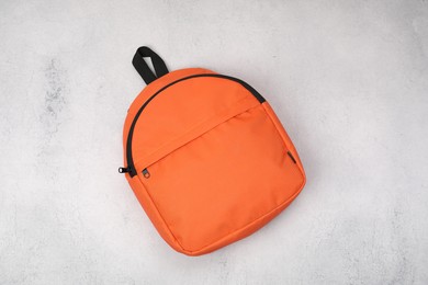 Photo of Orange school backpack on light grey table, top view