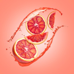 Image of Juice splashes and fresh red oranges in air on coral color background