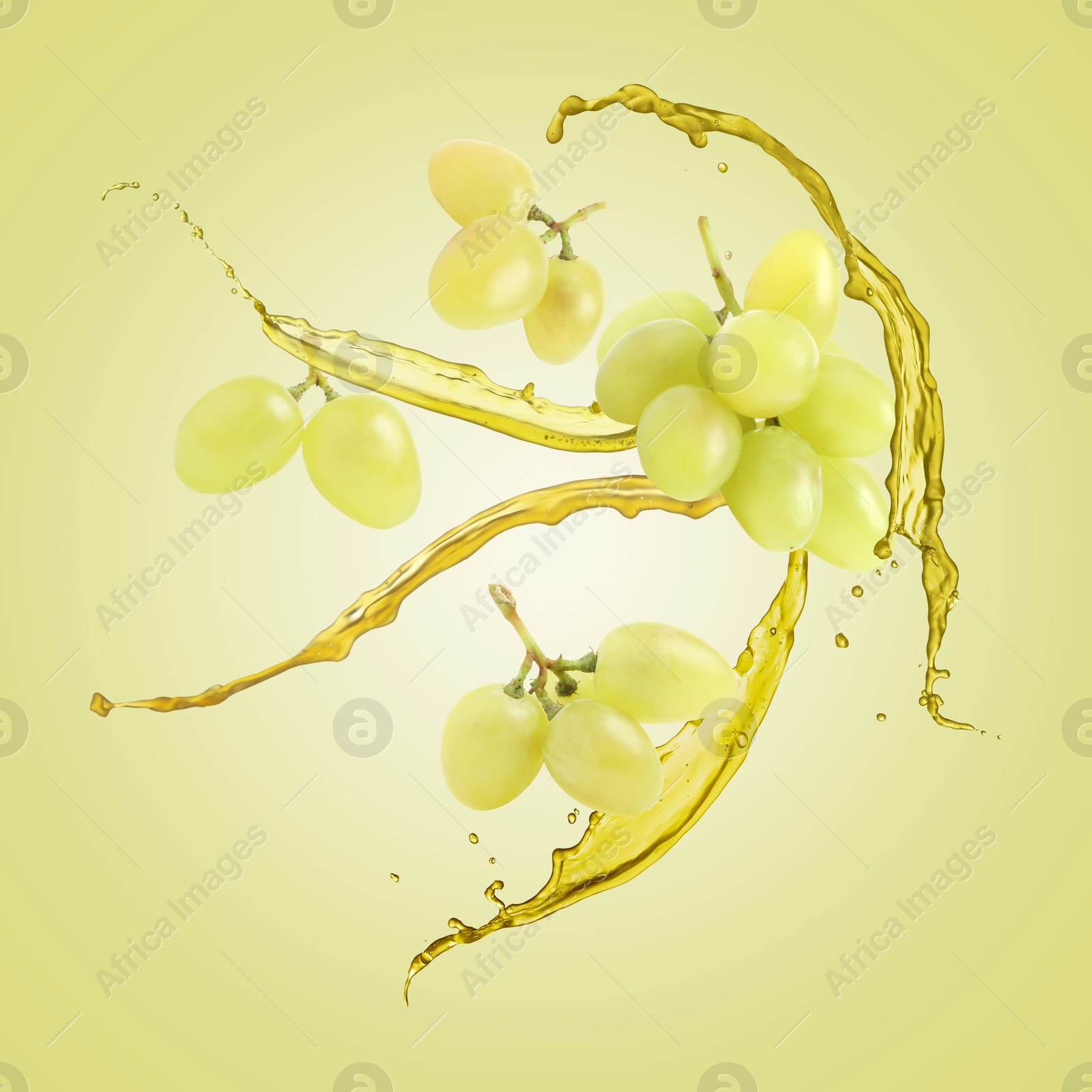 Image of Juice splashes and fresh grapes in air on yellowish green background