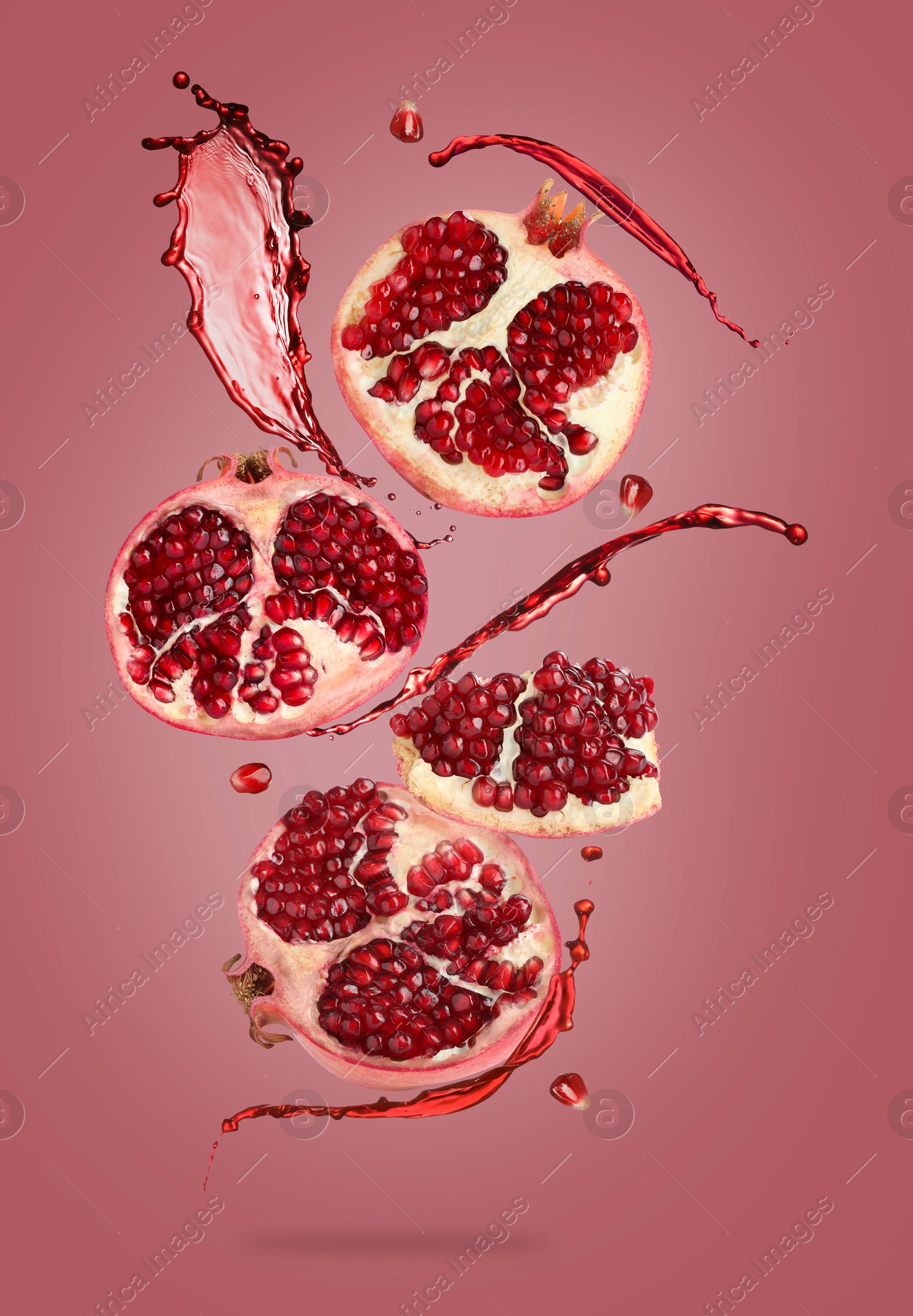 Image of Juice splashes and fresh pomegranates in air on red background