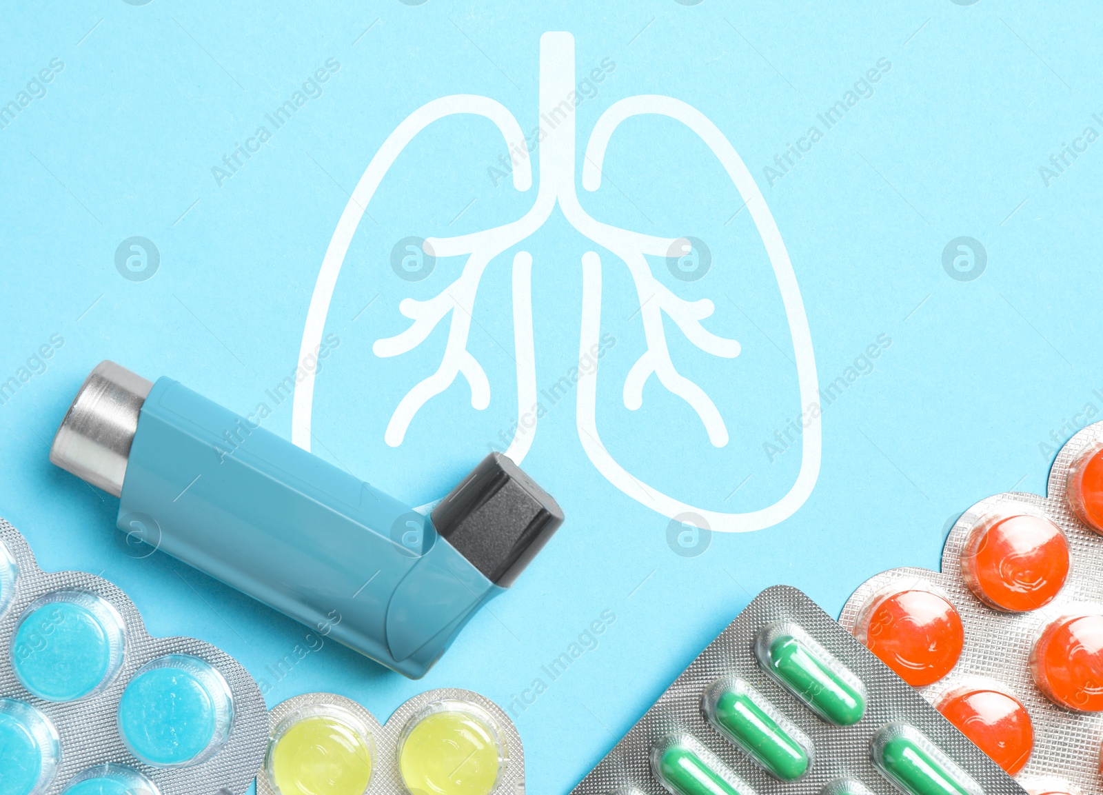 Image of Asthma inhaler, drugs and illustration of lungs on light blue background, flat lay