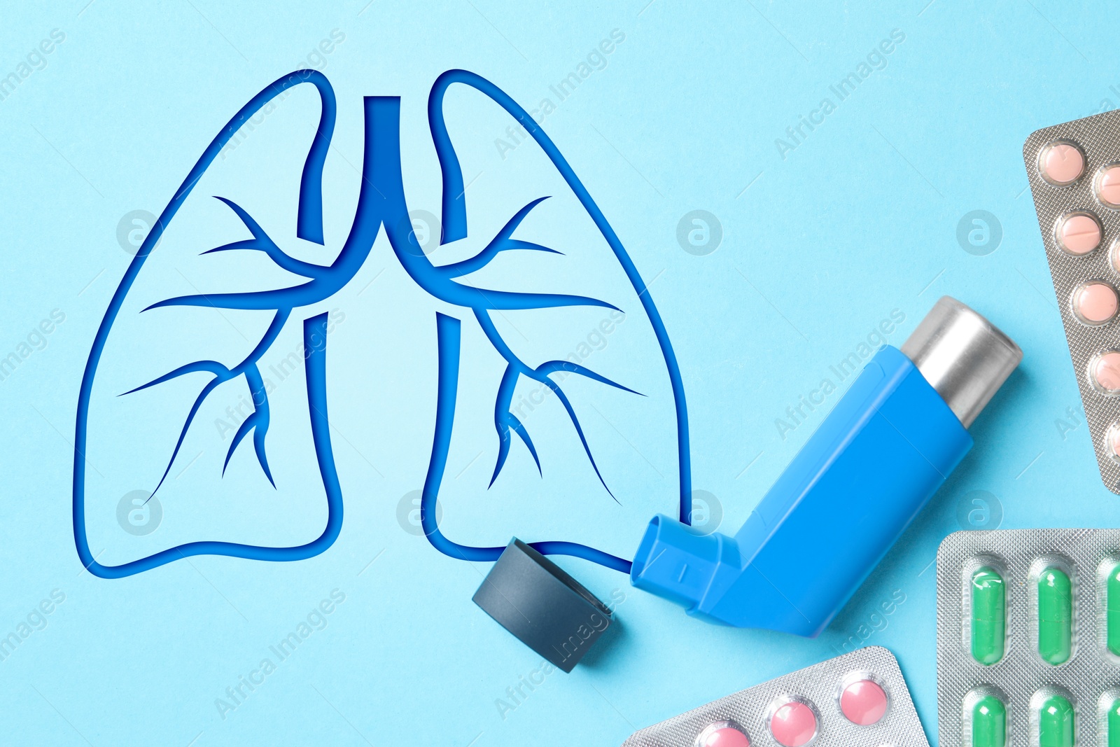 Image of Asthma inhaler, drugs and illustration of lungs on light blue background, flat lay