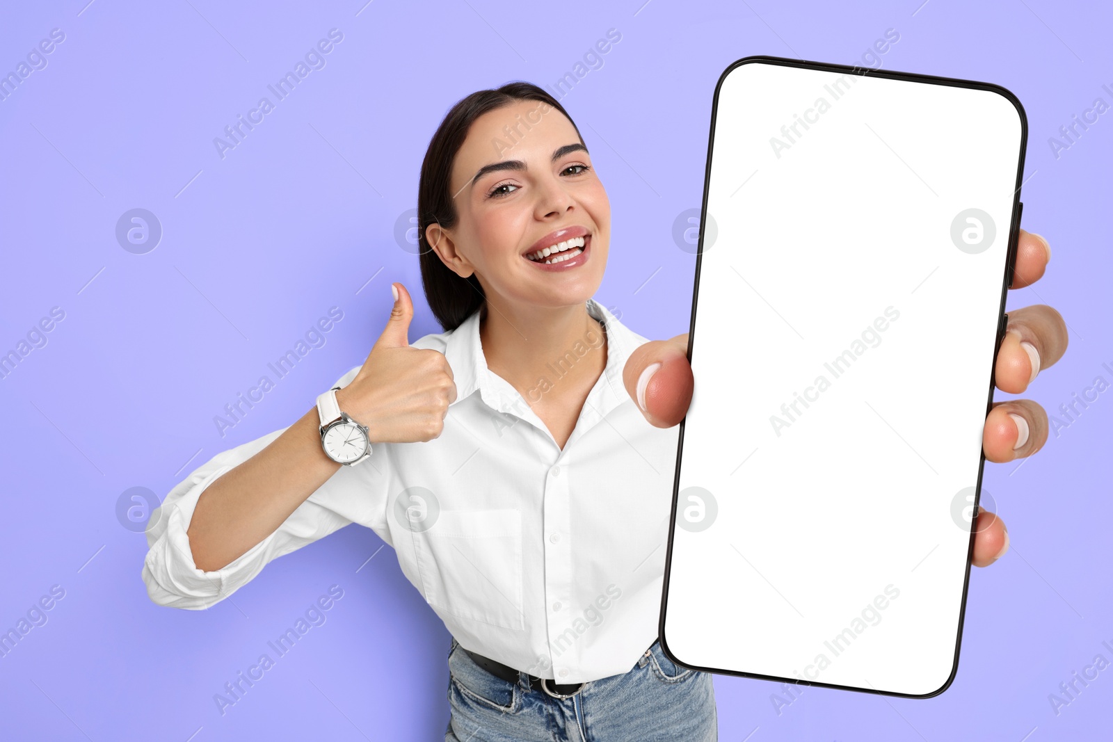 Image of Happy woman showing mobile phone with blank screen on blue violet background. Mockup for design