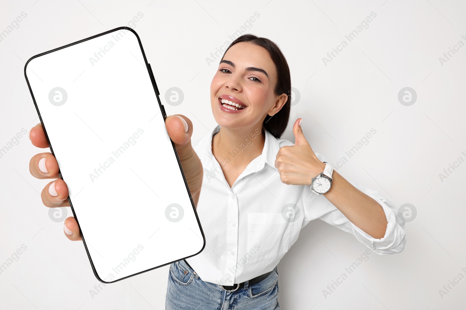 Image of Happy woman showing mobile phone with blank screen on white background. Mockup for design