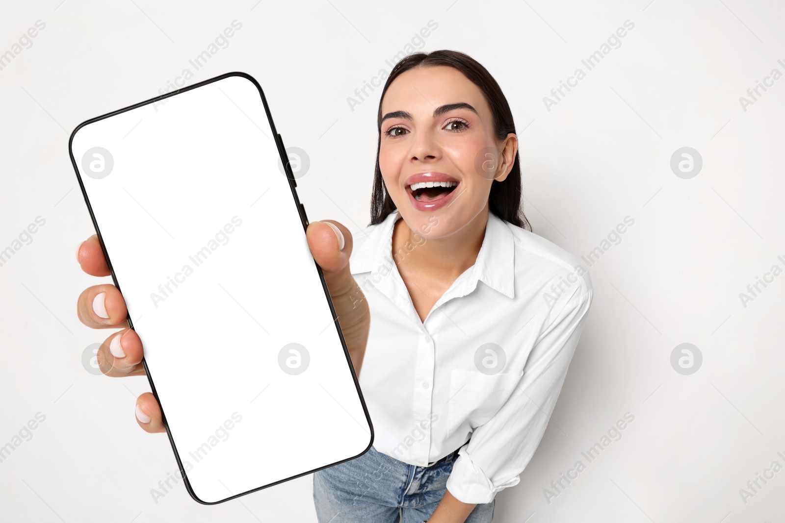 Image of Happy woman showing mobile phone with blank screen on white background. Mockup for design