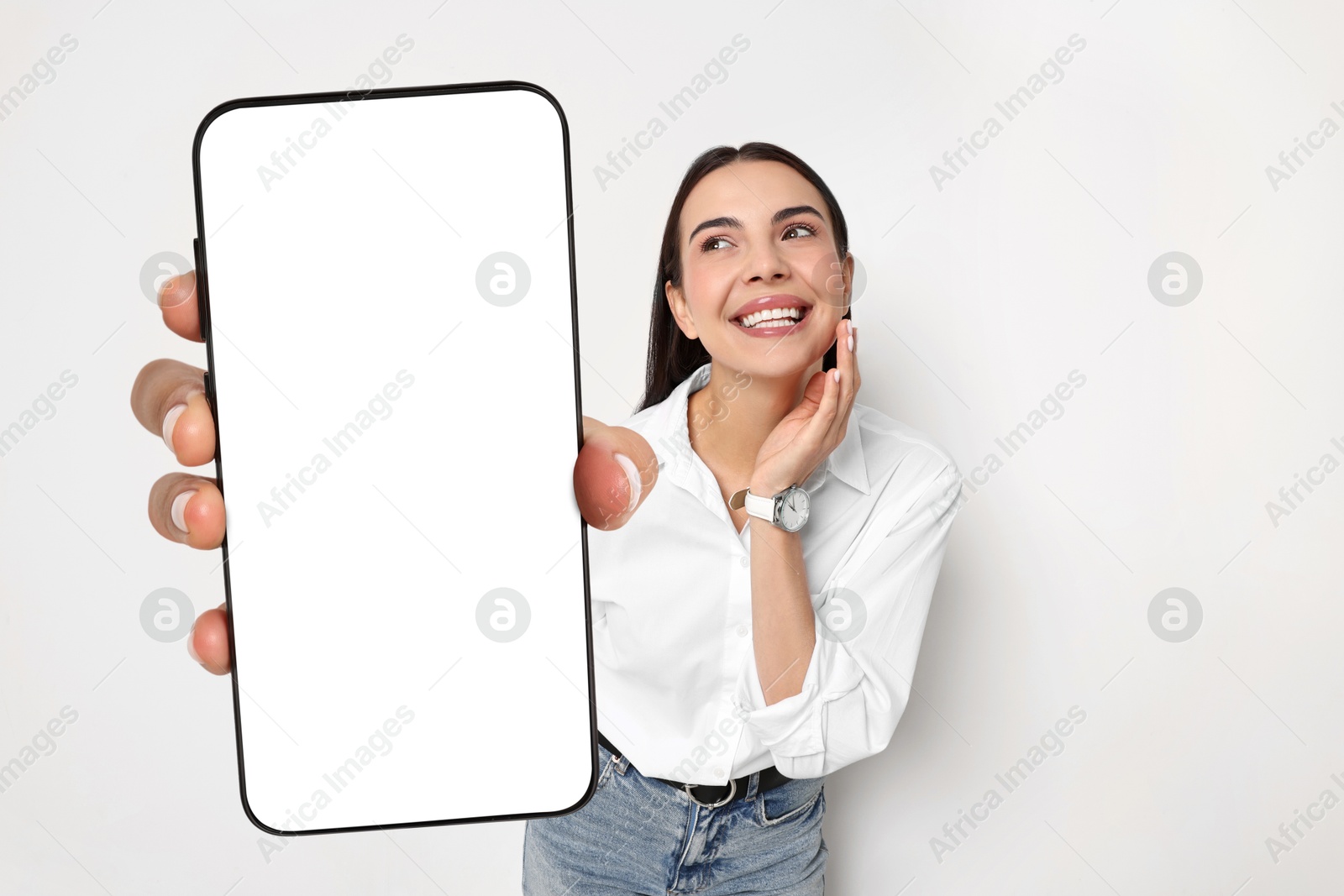 Image of Happy woman showing mobile phone with blank screen on white background. Mockup for design