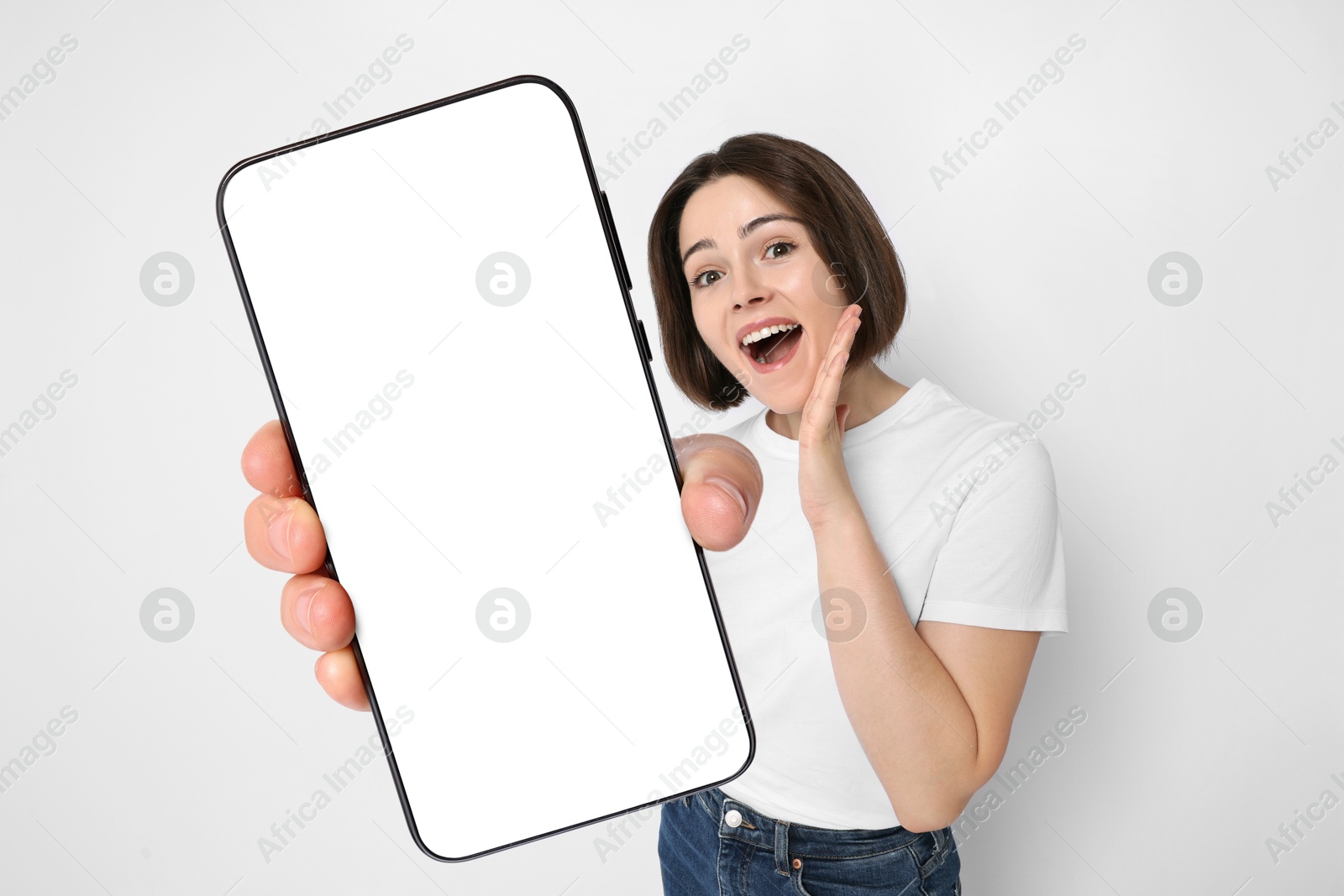 Image of Happy woman showing mobile phone with blank screen on white background. Mockup for design