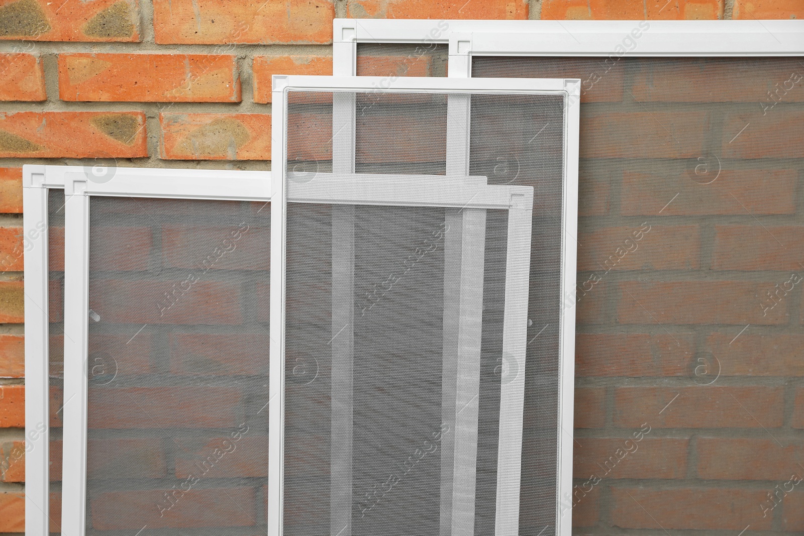 Photo of Set of window screens near brick wall